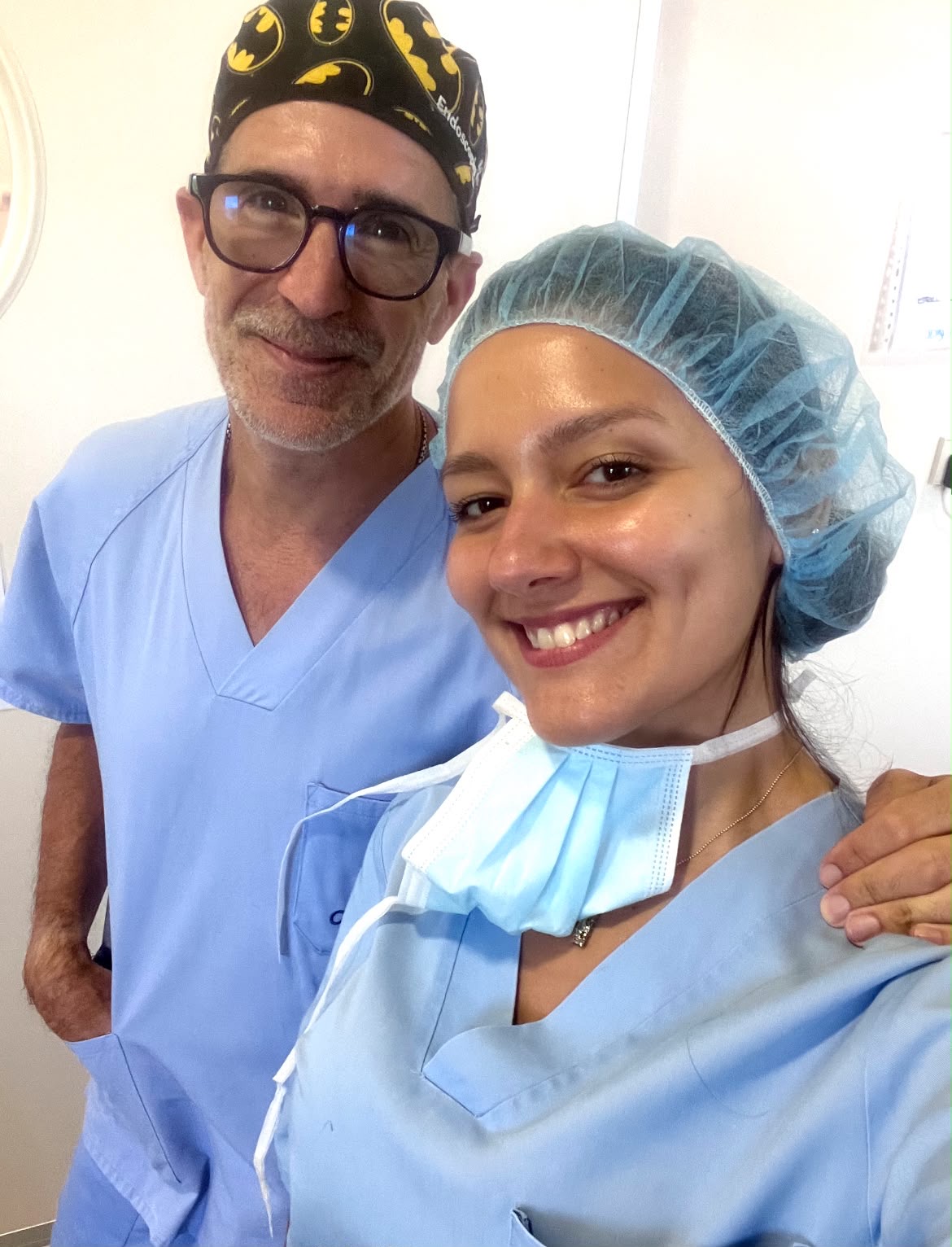 Dos profesionales sanitarios con ropa quirúrgica, sonriendo
